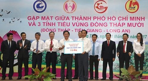 Lãnh đạo UBND tỉnh Đồng Tháp nhận bản tượng trưng tiền tài trợ của doanh nghiệp nhằm hoàn thiện hạ tầng nông thôn